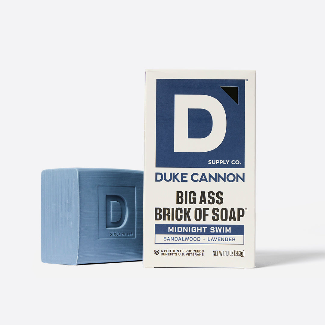 A blue brick of soap with 'Duke Cannon' on the packaging box which reads 'BIG ASS BRICK OF SOAP MIDNIGHT SWIM'.